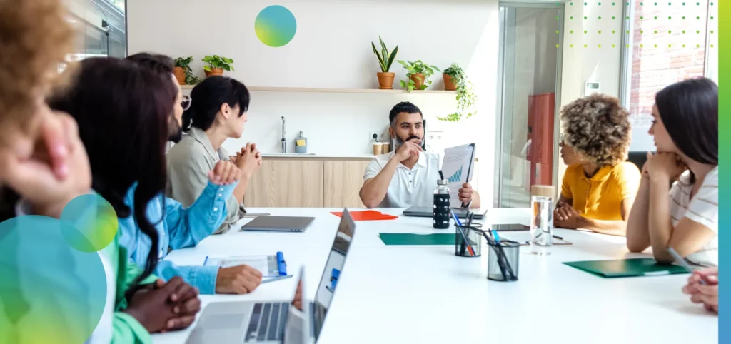 Multiracial employees listening to their manager at a company meeting.