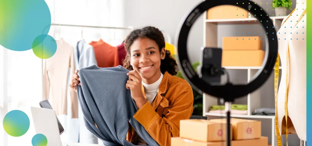 Woman designer entrepreneur showing clothes product on live online social media streaming.