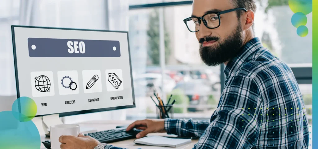 A young successful SEO manager sitting at workplace with computer.