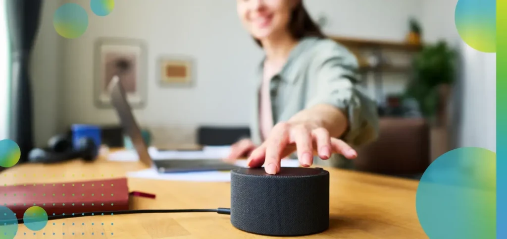 Woman enabling Amazon Alexa voice assistant at home, while working on her laptop.