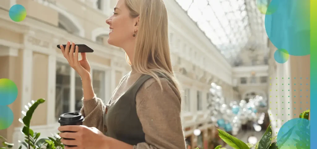Woman talking on her phone, outside while holding a cup of coffee.