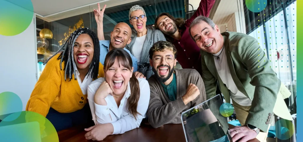 Diverse group of coworkers laughing together during a cheerful office meeting.