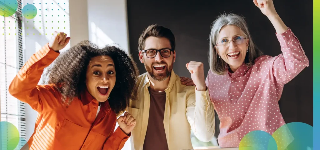 Architects celebrating success looking at laptop in the office.