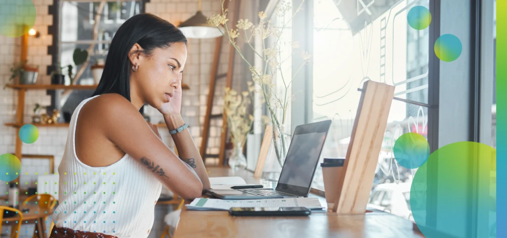 Woman on a laptop at a cafe, watching a video or typing and writing a report at a restaurant. 