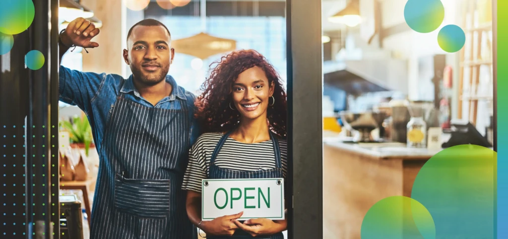 Smiling Business Owners Holding an Open Sign 