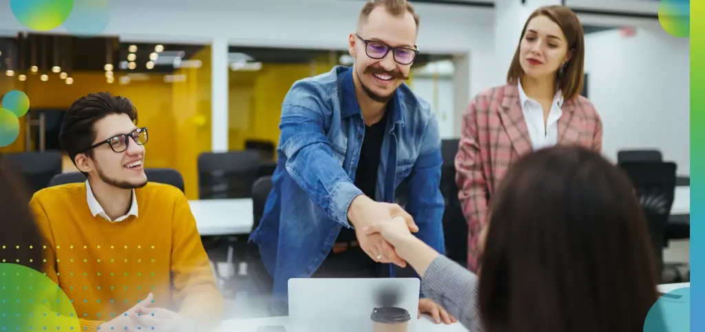 Business Professionals Shaking Hands at Conference Table